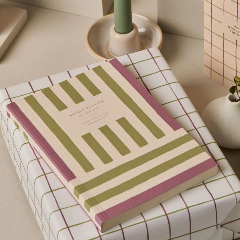 Agenda perpétuel Spring Ink & Bloom posé sur un bureau - couverture lin embossée rayures vert sauge et mauve format A5