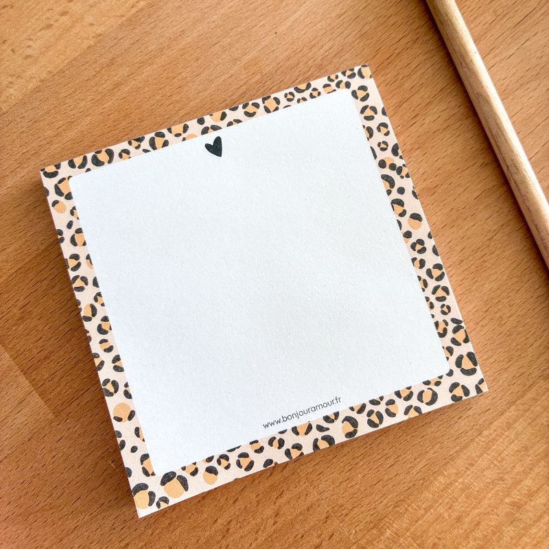 Bloc-notes encollé Graou à bordure léopard posé sur un bureau en bois avec un crayon