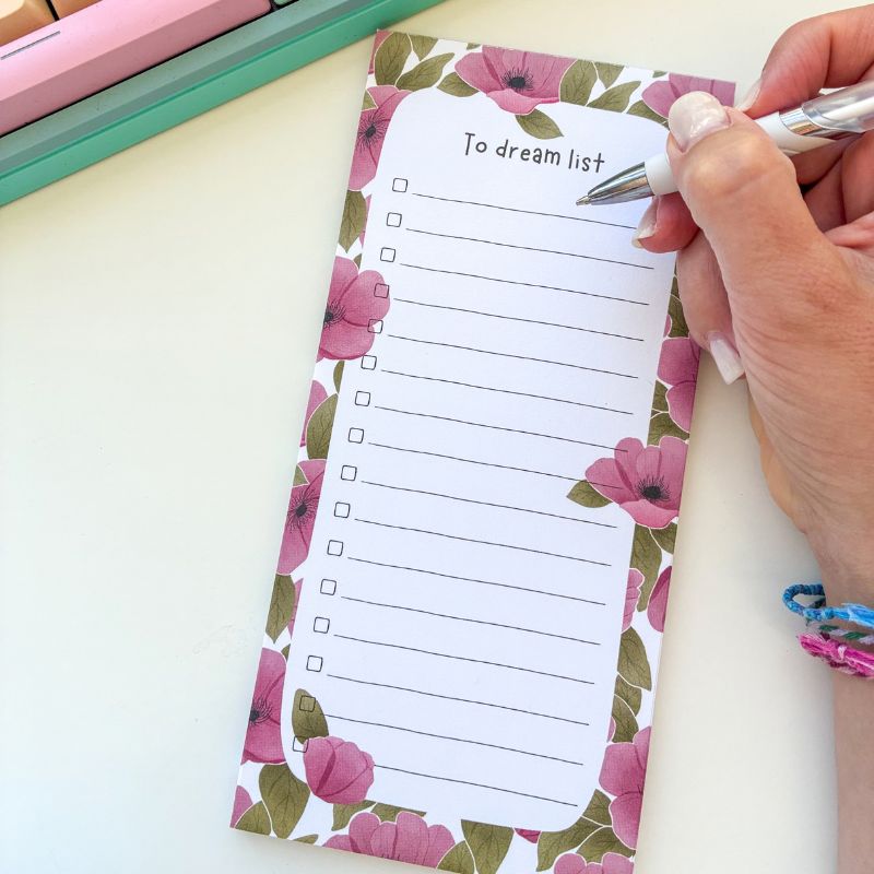 Bloc-notes To-Do List Spring utilisé avec un stylo, liste à cocher fleurie sur bureau