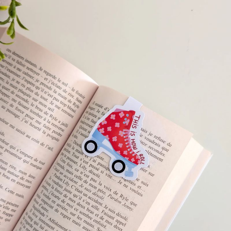 Marque-page magnétique Roller clipsé sur les pages d'un livre ouvert, illustration patin à roulettes rouge fleuri