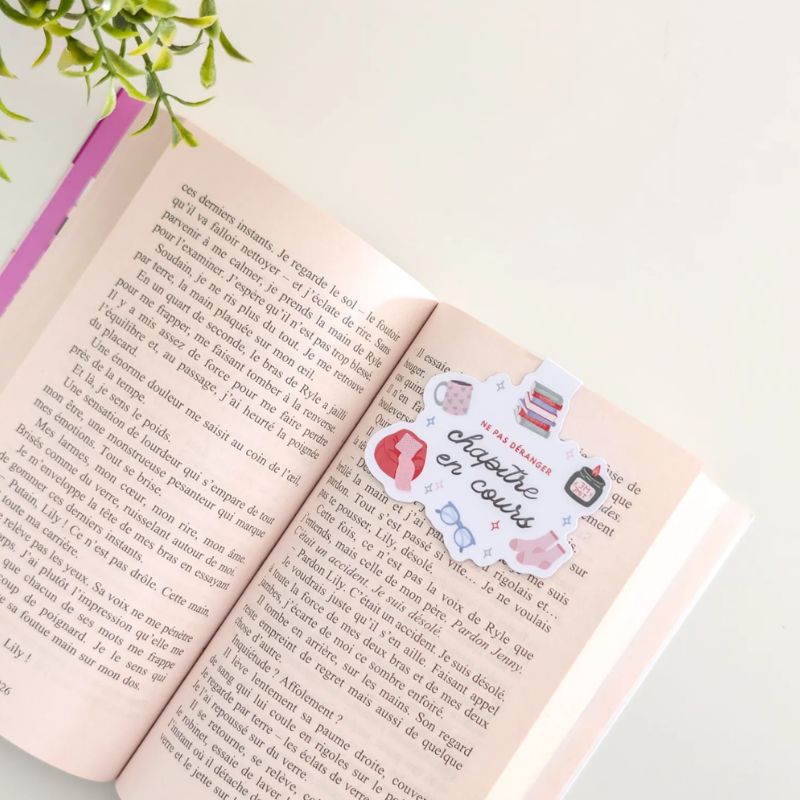 Marque-page magnétique Cosy clipsé sur les pages d'un livre ouvert, illustration cocooning automnale