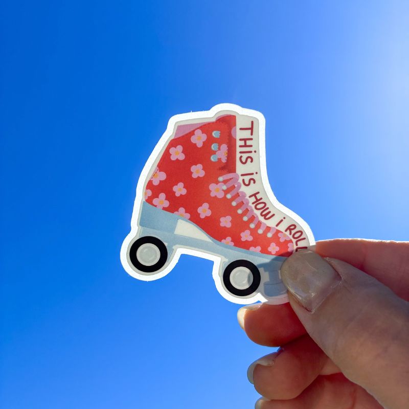 Sticker Roller tenu à la main devant un ciel bleu, patin à roulettes rouge "This is how I roll"